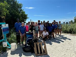 group of students standing behind a pile of trash they picked up at a beach cleanup day